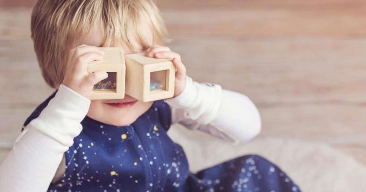 A toddler wearing a baby 'sleeping bag' covered in stars