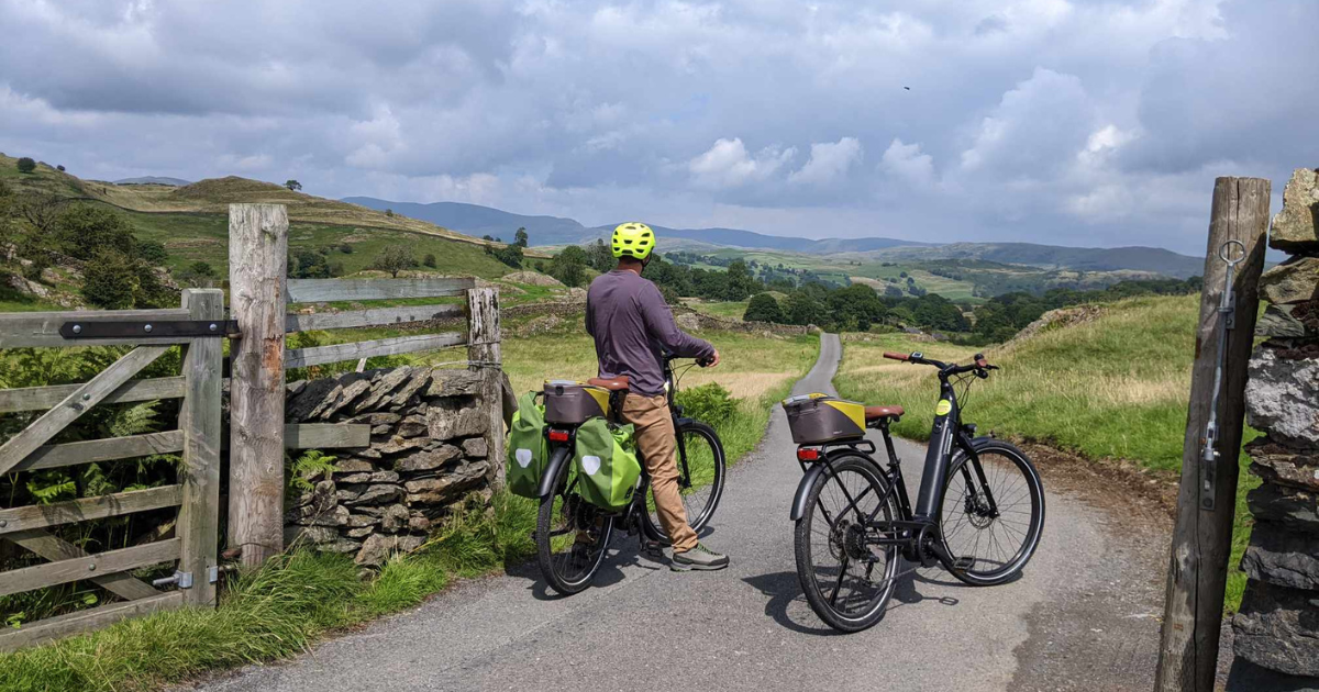 A person with an ebike looking at a view of a sunny landscape near Staveley