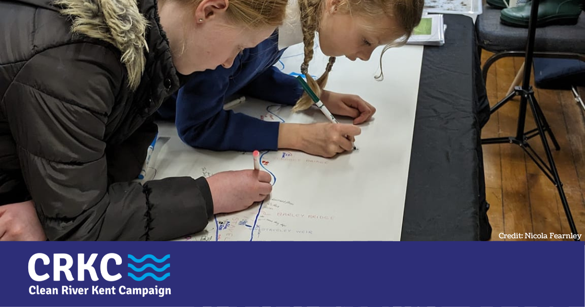 Two young people adding their thoughts to a diagram of the river Kent at the United Utilities drop-in event in Staveley in January 2024.