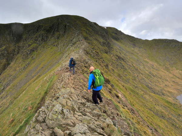 Two people carefully making their way along a Helvellyn ridge