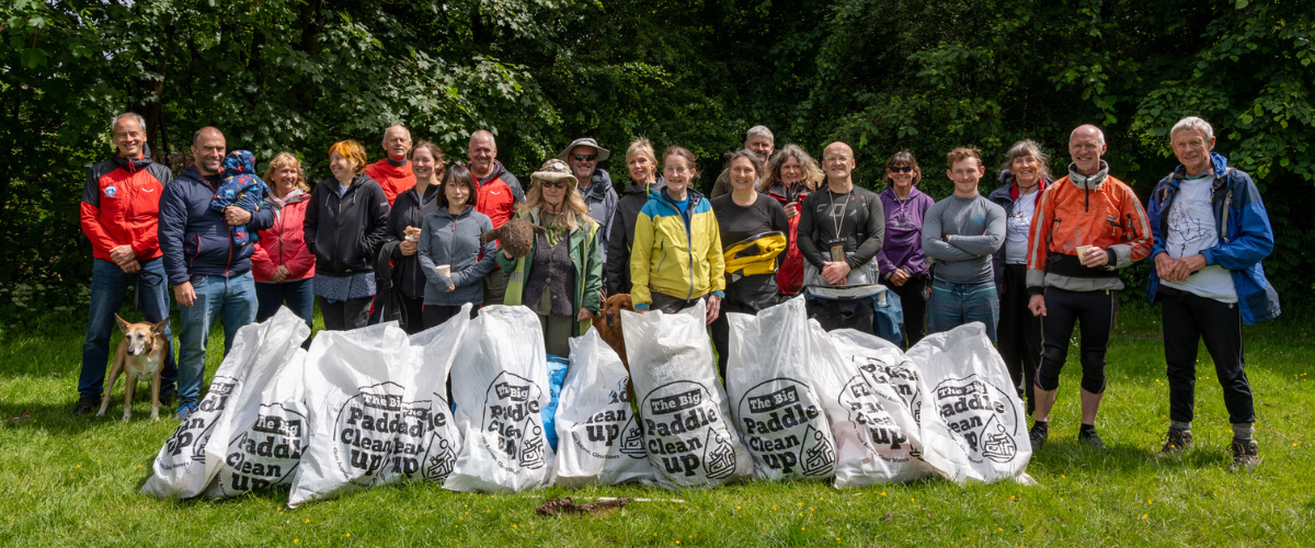 A group of around 30 people behind bags of litter picked up at the Great Big Green Week river clean up